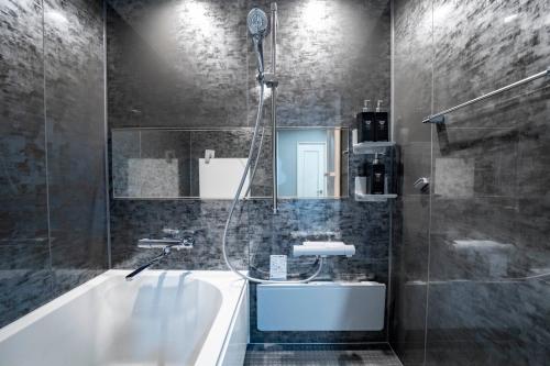 a bathroom with a tub and a shower and a sink at MP STYLE SAPPORO-35 in Minami-jūichijō