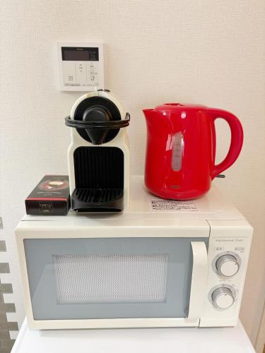 a microwave with a coffee pot on top of it at 和宿 湯沢チャオ Wayado Yuzawa Ciao in Yuzawa