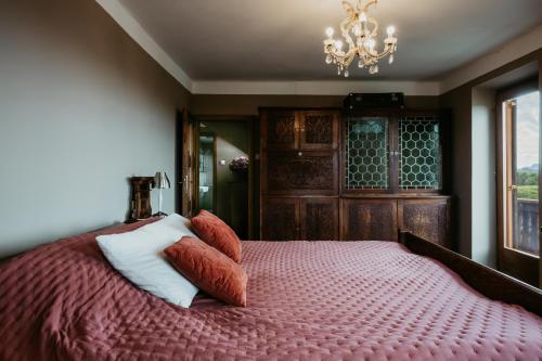 a bedroom with a bed with pillows and a chandelier at Hisa Vina in Podlehnik