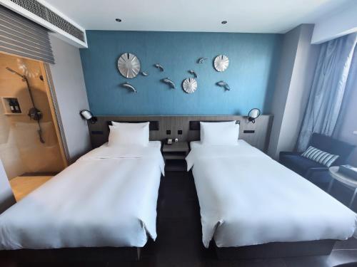 two beds in a room with blue walls at 杭州西湖武林广场银泰桔子水晶酒店 in Hangzhou
