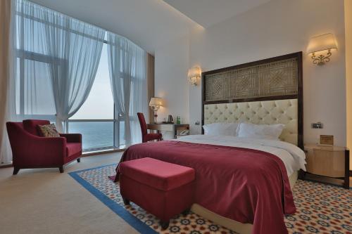 a bedroom with a large bed with a large window at KADORR Hotel Resort & Spa in Odesa