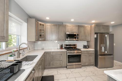 a kitchen with wooden cabinets and stainless steel appliances at Love 'n Life Haven in Cincinnati