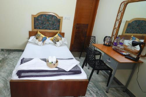 a bedroom with a bed with a desk and a bed sidx sidx sidx at NALINAM HOMESTAY in Trivandrum