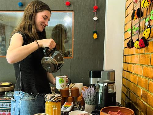a woman is pouring coffee into a cup at Runaway Eco Hotel in Carhuaz