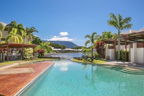 a swimming pool at a resort with a river at Blue Lagoon Resort in Trinity Beach