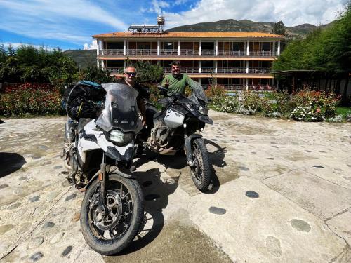 two men are standing next to their motorcycles at Runaway Eco Hotel in Carhuaz