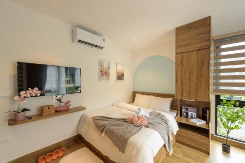 a bedroom with a bed and a flat screen tv at Crescendo Limitless Style in Hanoi