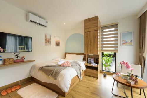 a bedroom with a bed and a table at Crescendo Limitless Style in Hanoi