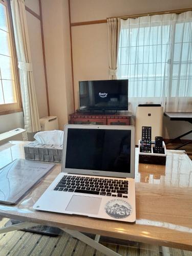a laptop computer sitting on a table in a living room at 和宿 湯沢チャオ Wayado Yuzawa Ciao in Yuzawa