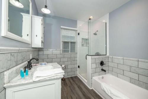 ein Badezimmer mit Waschbecken, Badewanne und Dusche in der Unterkunft The Restful Roost w Hot Tub in Columbus