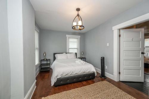 ein Schlafzimmer mit einem Bett mit weißer Bettwäsche und einem Fenster in der Unterkunft The Restful Roost w Hot Tub in Columbus