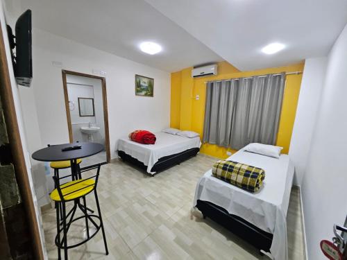 a room with two beds and a table in it at Hotel Nacional Palace in Foz do Iguaçu