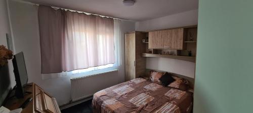 a small bedroom with a bed and a window at Apartament 2 camere R4 in Siret