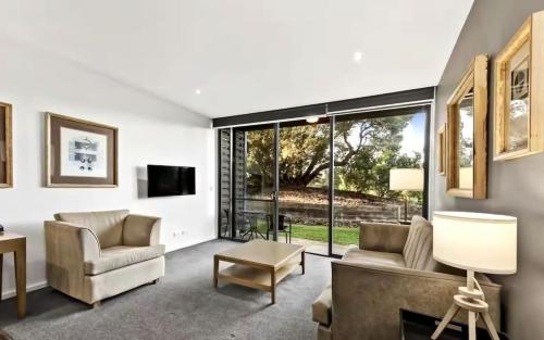 a living room with a couch and chairs and a tv at Golf Apartment Heated Pool 27 in Fingal