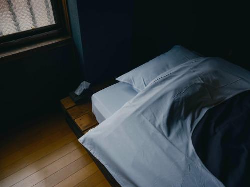 an unmade bed in a room with a window at Machigoto Hotel LOOP-Akamatsu Street - Vacation STAY 94005v in Kobayashi