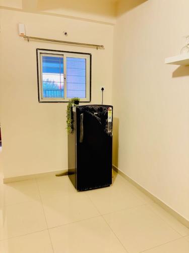 a black refrigerator in a room with a window at Peaceful AC 1BHK Near Forest Reserve Hadapsar in Pune