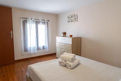 a bedroom with a bed with towels on it at Mani Sea & Stone House in Pirgos Dhirou