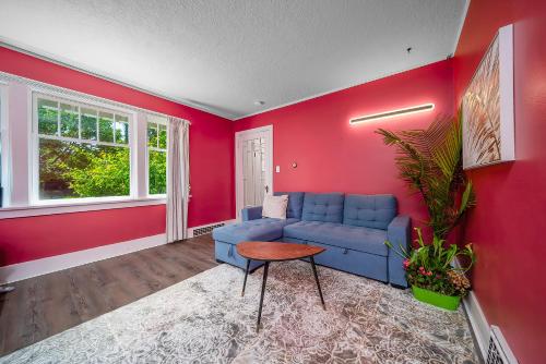 a living room with a blue couch and a red wall at Cozy four bedroom House in Vancouver West in Vancouver