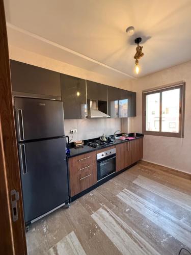 a kitchen with a black refrigerator and wooden cabinets at Julie's Private Apartment in Marrakech