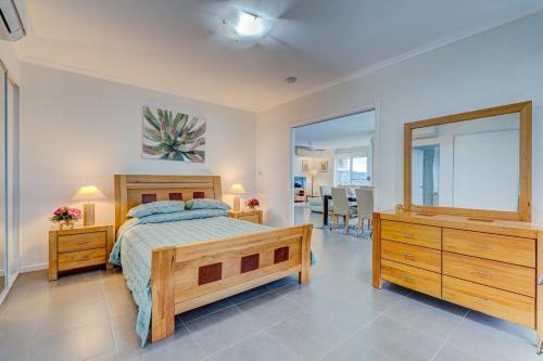 Un dormitorio con una cama, una cómoda y un espejo. en Rivergrande Apartment, en Innisfail