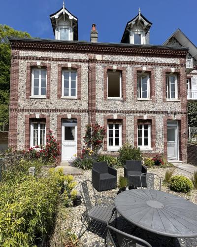 un bâtiment en briques avec une table devant lui dans l'établissement Chambres d'Hôtes Stella Mare, à Yport