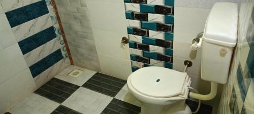 a bathroom with a white toilet in a room at White Desert Home Stay in Dhordo