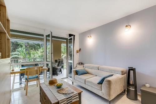 un salon avec un canapé et une table dans l'établissement Saint Laurent Apt Garden View - Happy Rentals, à Menton
