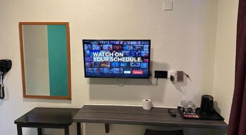 a television on a wall in a room with a table at Darlene Hotel in Singapore