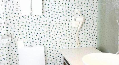 a bathroom with a sink and a toilet in it at Grand Nest Hotel (Tang Jia Wan Beach) in Zhuhai