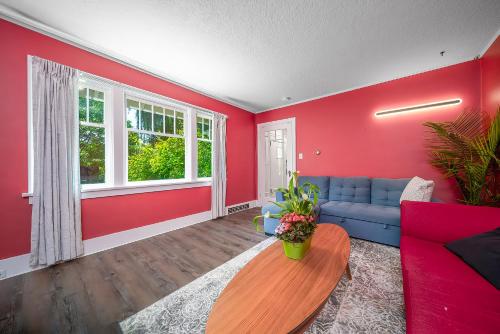 a living room with red walls and a blue couch at Cozy four bedroom House in Vancouver West in Vancouver