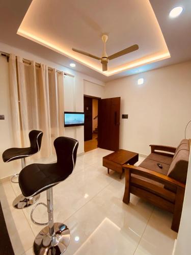 a living room with two chairs and a couch at Serene Apartments in Ernakulam
