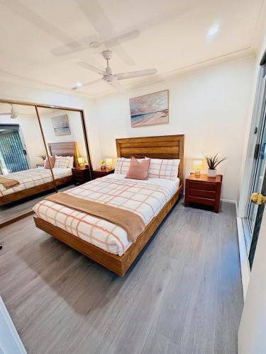a bedroom with a large bed and two tables at The Urban Cozy Cottage - 5 Mins to Parramatta or Westmead Hospital or WSU in Wentworthville
