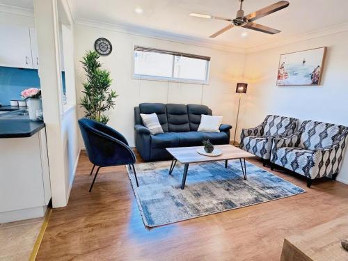 a living room with a couch and a table at The Urban Cozy Cottage - 5 Mins to Parramatta or Westmead Hospital or WSU in Wentworthville