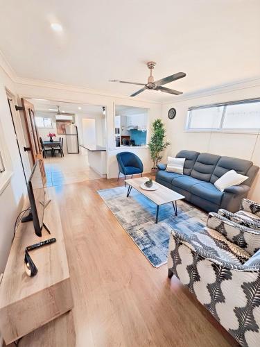 a living room with a couch and a table at The Urban Cozy Cottage - 5 Mins to Parramatta or Westmead Hospital or WSU in Wentworthville