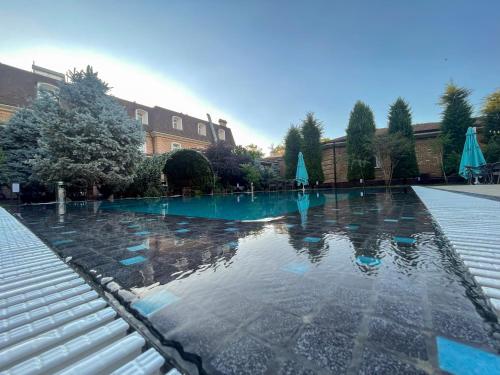 a swimming pool with blue water in front of a building at HL 309 Hotel in Tashkent