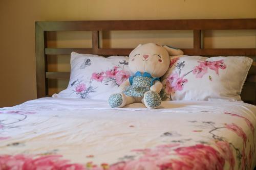 a teddy bear sitting on top of a bed at Cozy four bedroom House in Vancouver West in Vancouver