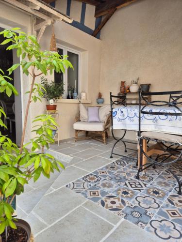 une terrasse avec une chaise, une table et un tapis dans l'établissement Le Percheron, à Avenay-Val-dʼOr