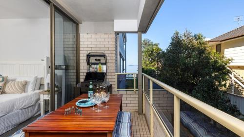 a patio with a wooden table on a balcony at Bangalee 2 at Sunrise in Soldiers Point