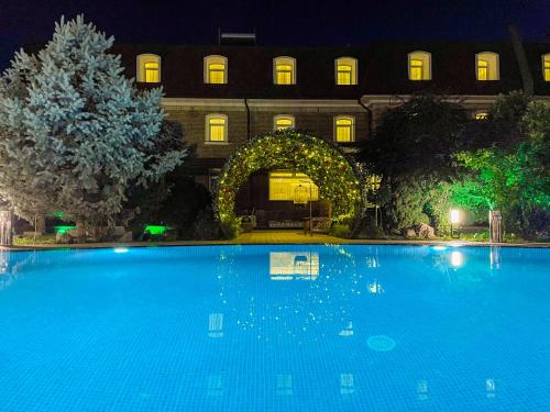 a large swimming pool in front of a building at night at HL 309 Hotel in Tashkent