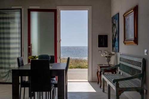 a dining room with a table and a view of the ocean at Rosa Dei Venti in Calabernardo