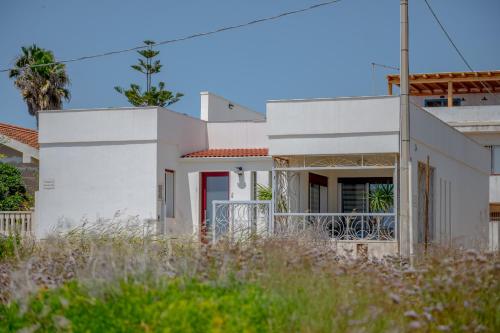 a white house with a red door at Rosa Dei Venti in Calabernardo