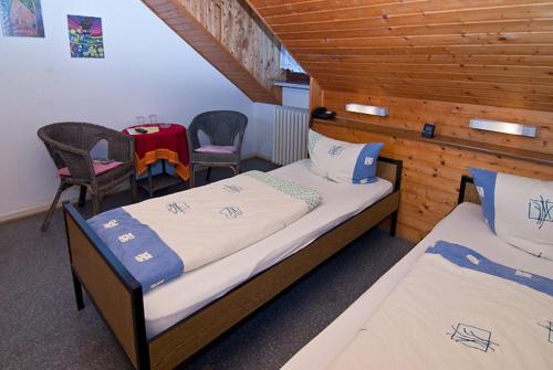 sypialnia z 2 łóżkami, stołem i krzesłami w obiekcie Hotel Kugel w Trewirze