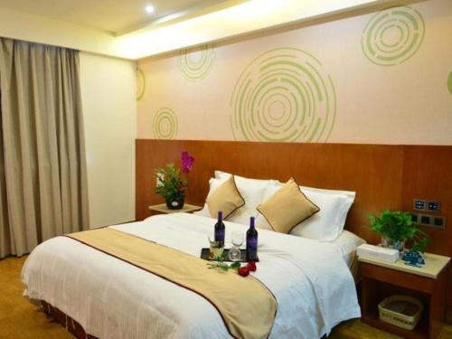 a hotel room with a large bed with flowers on it at GreenTree Inn Qingdao Jiaozhou Jiaoping Road Express Hotel in Qingdao