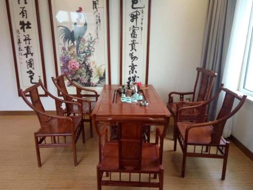 a dining room with a wooden table and chairs at GreenTree Inn Qingdao Jiaozhou Jiaoping Road Express Hotel in Qingdao