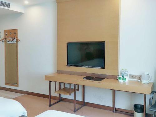 a living room with a television on a table at GreenTree Inn Qingdao Jiaozhou Jiaoping Road Express Hotel in Qingdao