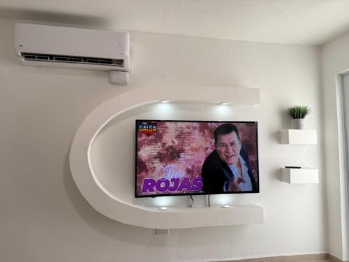 a flat screen tv on a wall in a room at Costa Relax - 5 in Arroyo