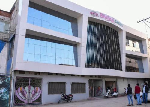 a large building with people standing outside of it at Hotel Shehnai Garden in Chhatarpur