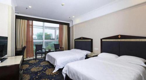 a hotel room with two beds and a large window at Zhongshan Hui Quan Hotel in Zhongshan