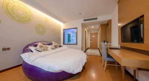 a bedroom with a large bed with a desk and a desk at GreenTree Inn Nantong University Industrial Expo City Express Hotel in Nantong