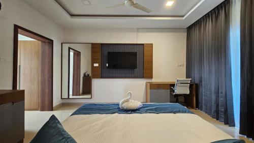 a bedroom with a bed with a television and a desk at West Bay MARISOL in Varkala